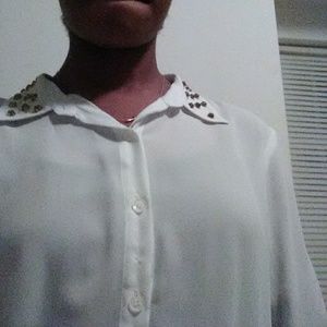A button down blouse with gold studs on the collar
